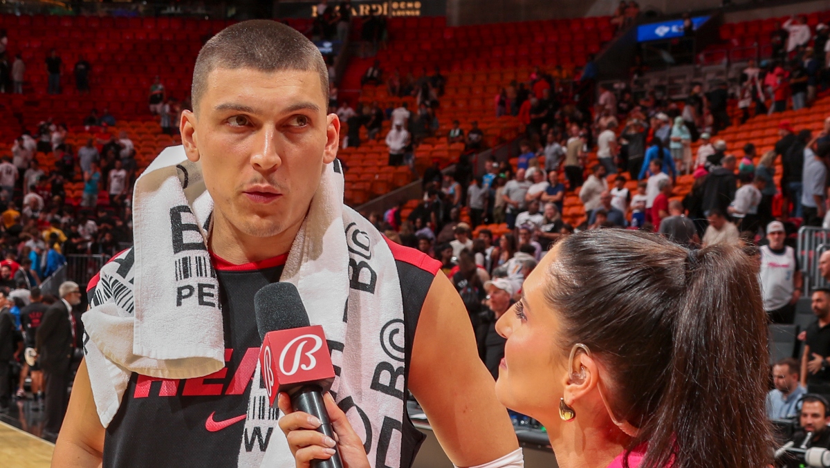 Tyler Herro handles the postgame interview while distracted by a fight in the stands